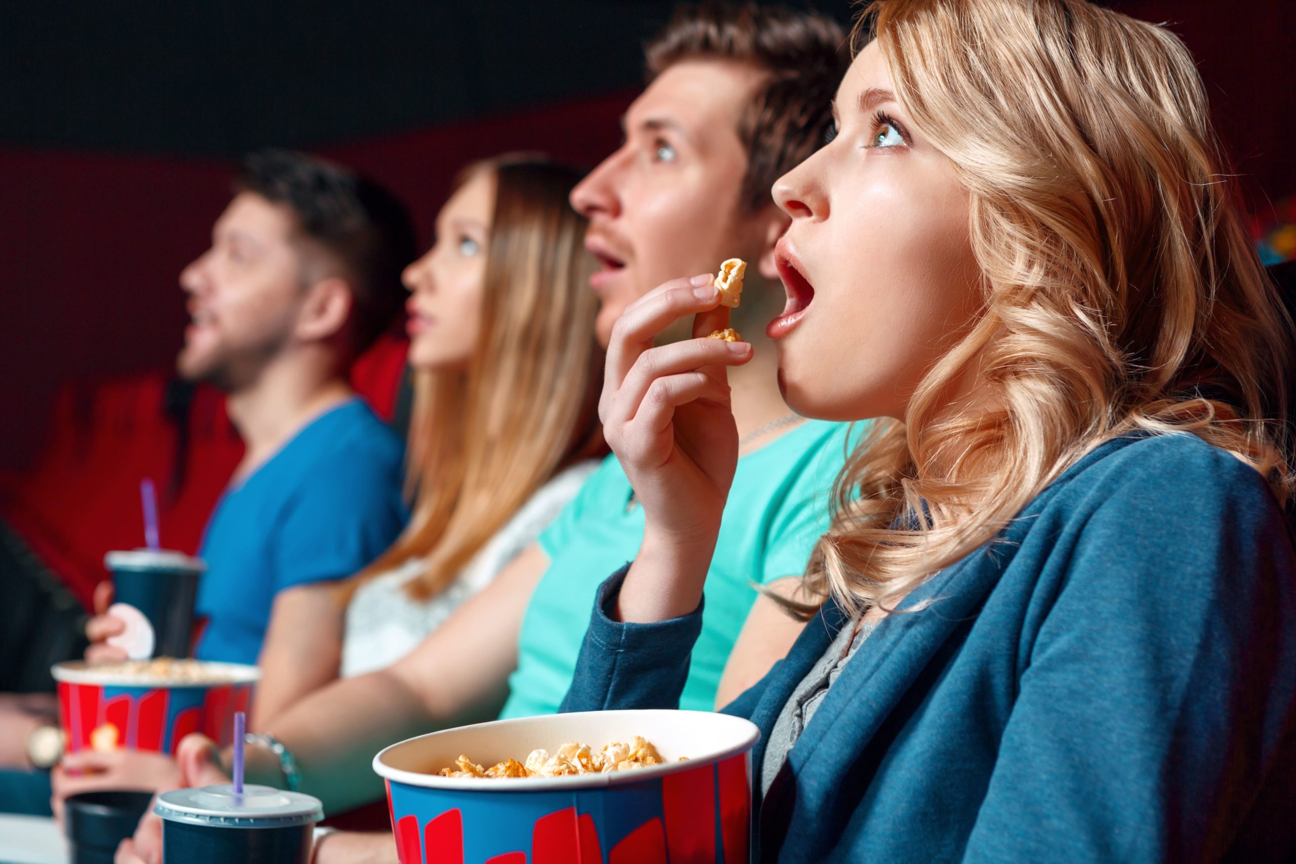 Просмотр. Кинотеатр. Попкорн в кинотеатре. Молодежь в кинотеатре. Зрители в кинотеатре.