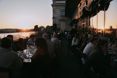 Coucher de soleil sur la Garonne depuis le rooftop La Belle en Folie Bordeaux, vue sur la place de la Bourse et le pont de Pierrre